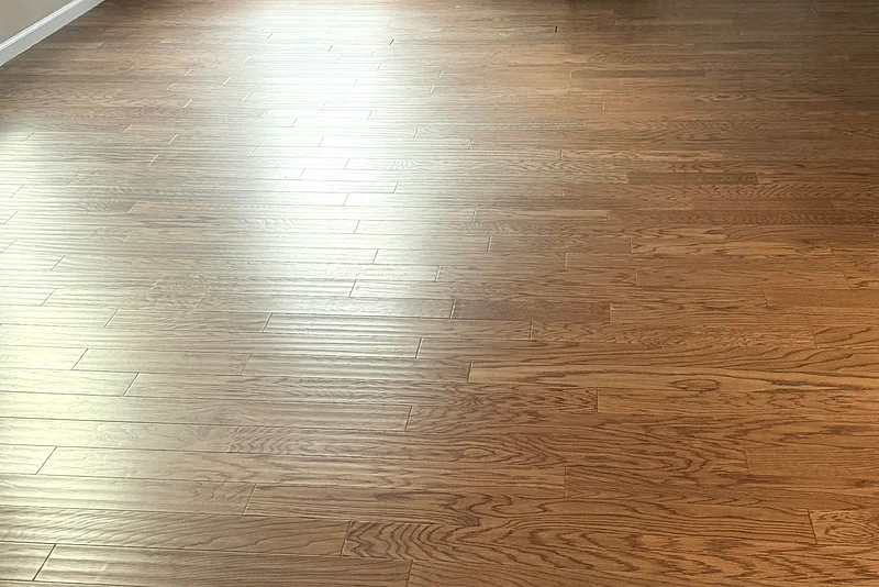 The same hardwood floor after cleaning: clean, glossy boards with the grain showing through