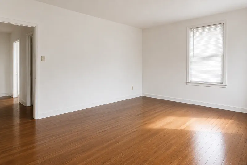 The same empty room after a move-out clean: bright walls and a polished floor