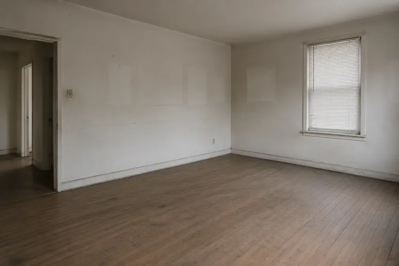Empty room before a move-out clean: scuffed walls and dull floor