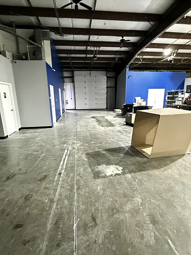 Dusty warehouse floor with tire marks and scuffing, before cleaning