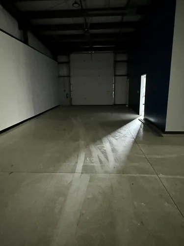 A stretch of grey warehouse concrete streaked with grime, before cleaning