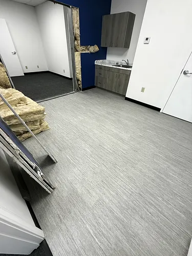 A kitchenette room with new vinyl flooring, wiped down and clean