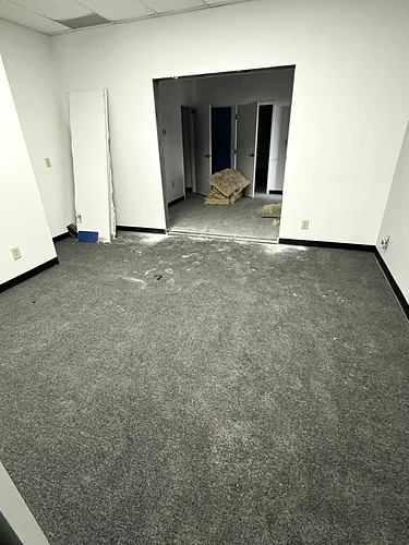 A grey office carpet before cleaning: dusty, marked and flattened by traffic