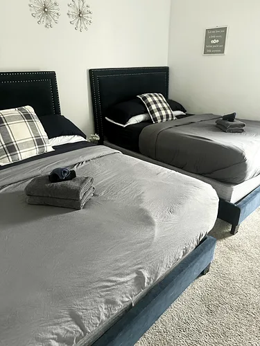 Two twin beds made up neatly in a cleaned rental bedroom