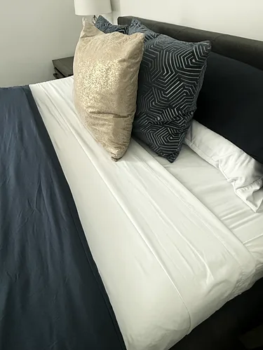 Freshly plumped pillows on a made bed after a rental turnover