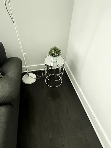 A dusted side table beside the sofa in a cleaned rental
