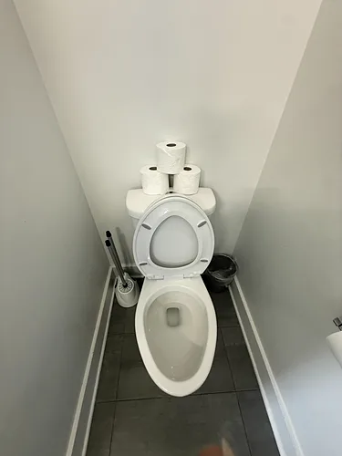 A cleaned and restocked toilet in a rental bathroom
