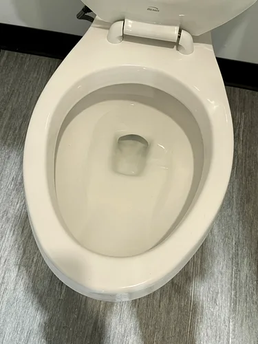 A close-up of a clean commercial toilet after service